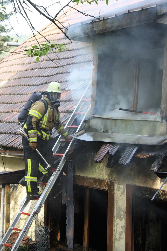 Mit Atemschutz drangen Feuerwehrleute von der Rückseite her in das Gebäude ein.