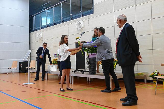 So wie Pia Grandis, Klassenbeste der 10a, erhielt jeder Absolvent eine Blume von Michel-David Wöhr (Zweiter von rechts). Felix Lehr ...