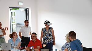 In der Sitzung des Gemeinderates von Unterkirnach besteht für Gemeinderäte und Zuhörer unter Anleitung von John Mohr (stehend links), ...