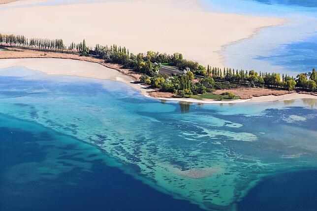 Noch dutzende Meter entfernt vom Inseldamm ist das Wasser im Gnadensee flach, was aus der Luft deutlich zu erkennen ist.