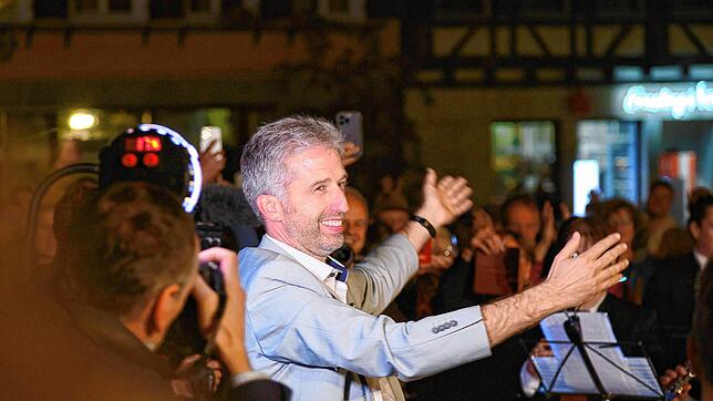 Boris Palmer dirigiert Musiker, die ihm nach geglückter Wiederwahl auf dem Tübinger Marktplatz an Ständchen bringen.