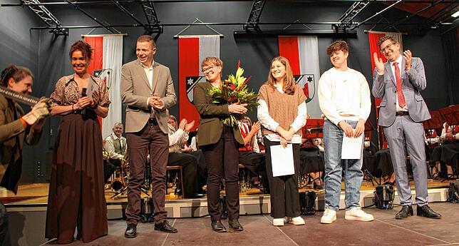 Ralph Gerster (rechts) freut sich mit seiner Familie über einen Holzbalken mit Sinnspruch, den Melanie Boos (ganz links) als Geschenk ...