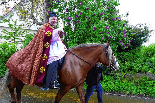 Pfarrer Jürgen Schmidt hoch zu Ross mit einer Reliquie des heiligen Georg.
