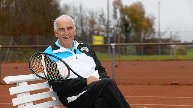 Rainer Kohler auf einer Bank auf einem der vier Tennis-Plätze des SV Litzelstetten. Der 77-Jährige ist und war die prägende Gestalt der ...
