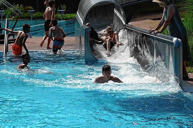 Groß und klein haben Lust auf die Wasserrutsche. Nach 50 Meter Wasserfahrt werden die Wasserrutscher ins Becken gespült.