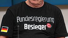 Der „Compact“-Chefredakteur tauscht direkt nach dem Urteil sein weißes Hemd gegen dieses T-Shirt mit der Aufschrift „Bundesregierung ...