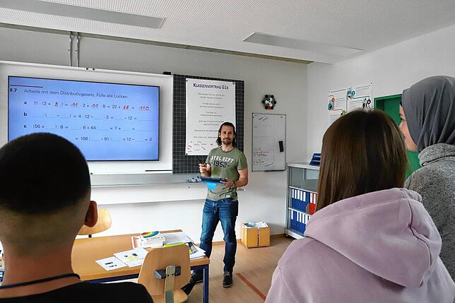 Unterricht mit digitalen Hilfsmitteln: Lehrer Flavio Fehr bespricht mit Schülern eine Mathematikaufgabe.