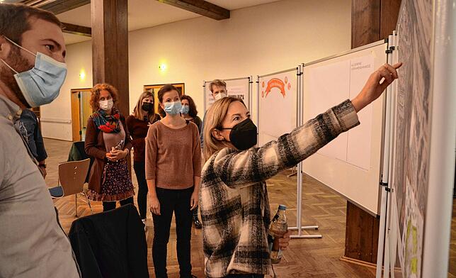 Interessierte Anwohner der beschlossenen neuen Grundschule in der Stadthalle: Auch mit Maske wird konzentriert an den vorläufigen Plänen ...