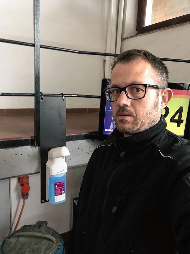 Der Kommandant der Feuerwehr Höchenschwand zeigt den am Gerätehaus installierten Desinfektionsspender.