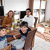 Dilan (vorne links), Kiyan sowie die Eltern Anastasia und Veysel Arslan am Wohnzimmertisch. Rechts die Eisenbahn, mit der die Kinder mit ...