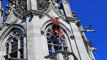 Pascal Harlaut hängt am Münsterturm am Seil, um die Turmwand nach Schäden und Rissen abzuklopfen.