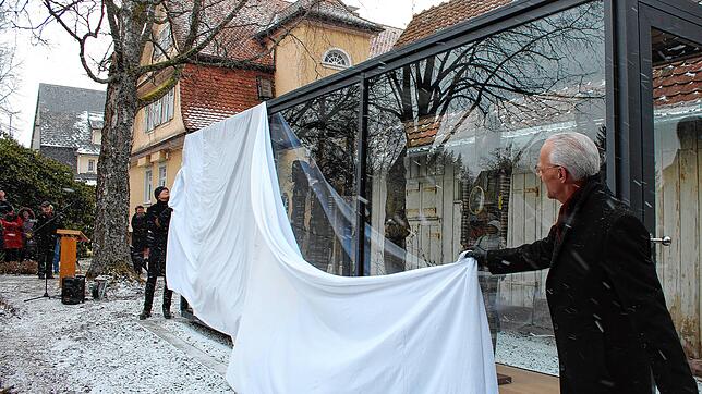 Bürgermeister Fritz Link (rechts) und der Königsfelder Künstler Jürgen Winckler enthüllen die Glasvitrine, in der sechs Kunstfiguren ...