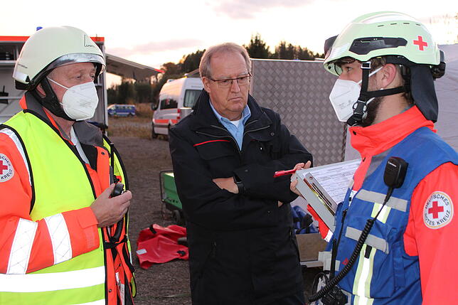 Thomas Ermer (Mitte), Vertreter des Landratsamts, bei der Lagebesprechung mit zwei Vertretern des Roten Kreuzes.