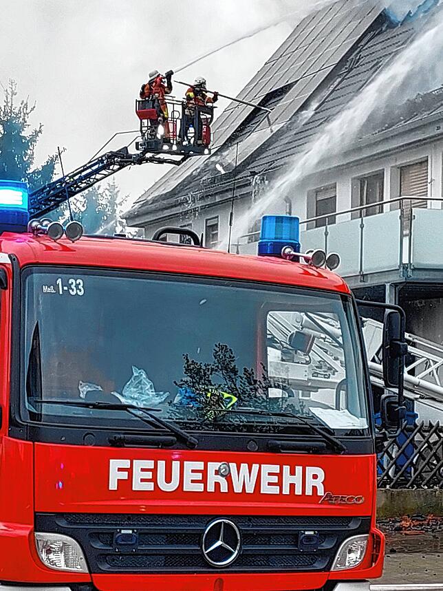 Verzweifelt versuchen die Männer ein Dachfenster einzuschlagen, um das Feuer im Inneren des Gebäudes besser bekämpfen zu können.
