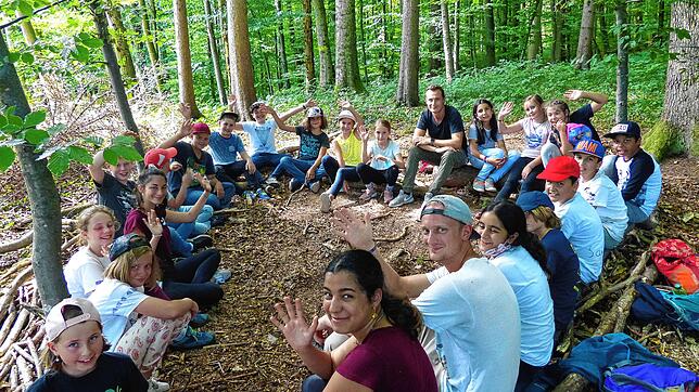 Äste und Stöcke wurden zu Sitzbänken für die fröhliche Runde: Der Tag im Wald mit Spielen, Erforschen, Basteln und Singen macht Kindern ...