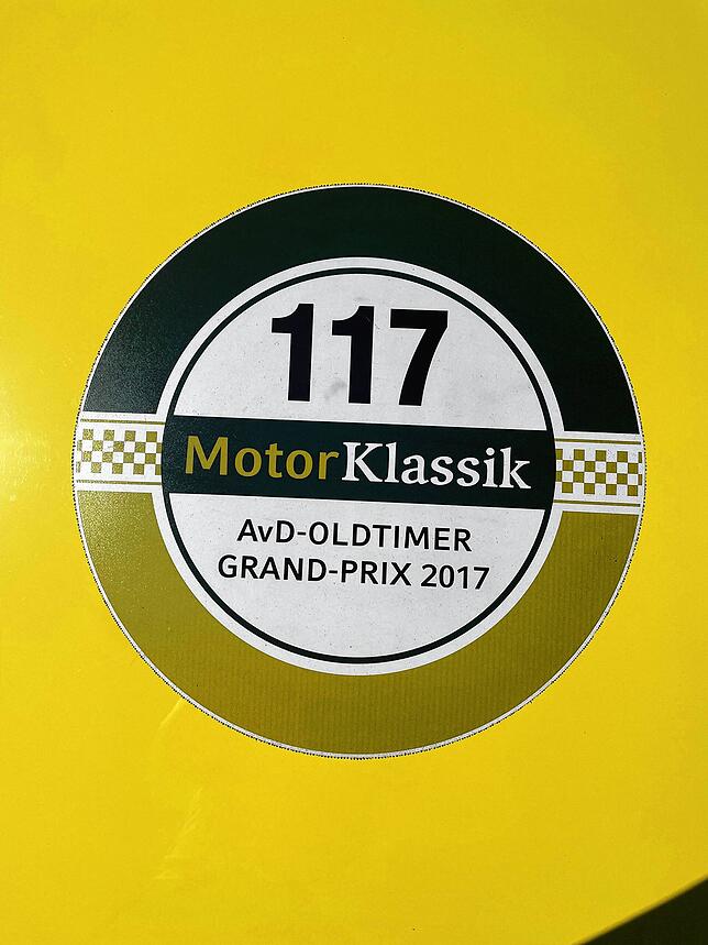 Sticker auf dem Fahrzeug erzählen von gemeinsamen Abenteuern. Hier eine Erinnerung an den Oldtimer Grand Prix 2017 in Nürnberg.