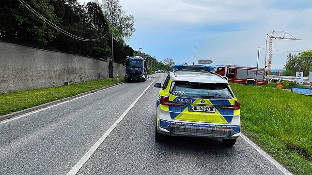 Ein Einsatzfahrzeug der Polizei auf der Bundesstraße 33, im Hintergrund ist der demolierte Betonmischer zu sehen.