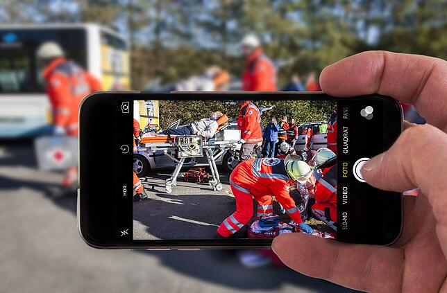 Schaulustige fotografieren bei einem Rettungseinsatz mit der Handykamera. (Symbolfoto)