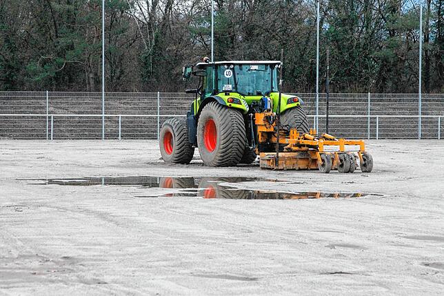 „Centre Court“: Der Traktor steht auf dem künftigen Naturrasenplatz. Ob er zu Saisonbeginn im August bespielbar ist, hängt ...