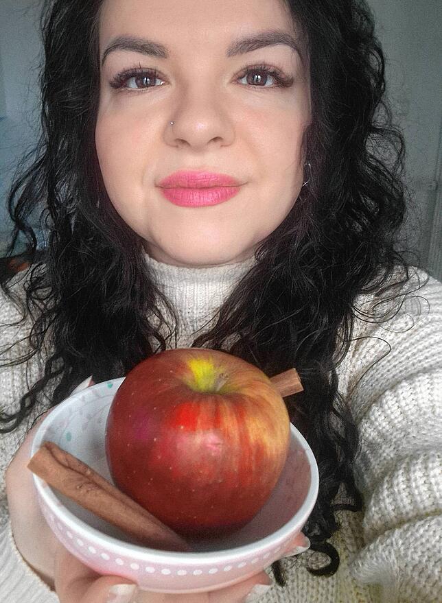 Äpfel und Zimtstangen machen aus einer Biskuitrolle ein weihnachtliches Dessert.