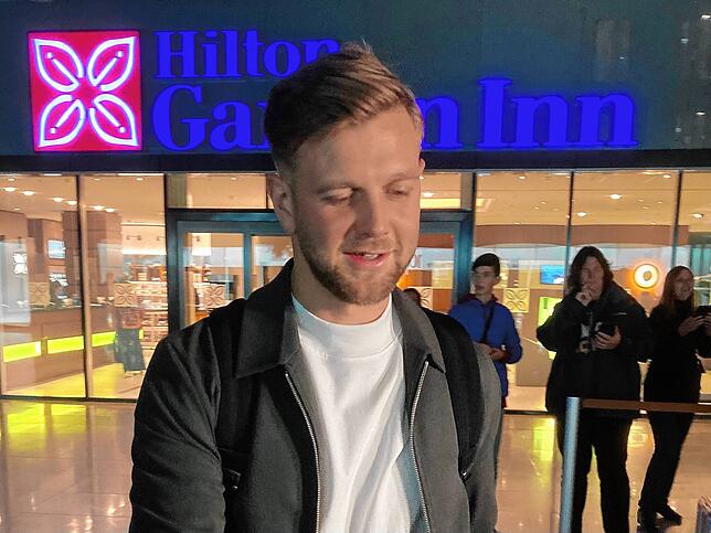 Nationalspieler Niclas Füllkrug gibt am Sonntagabend vor dem DFB-Teamhotel am Frankfurter Flughafen Autogramme.