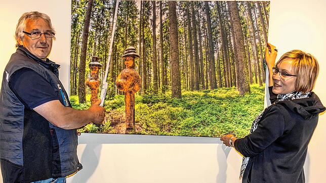 Leiterin Kathleen Mönicke und Hausmeister Georg Müller haben die großformatigen Bilder der neuen Ausstellung &bdquo;Natur? Kunst? ...