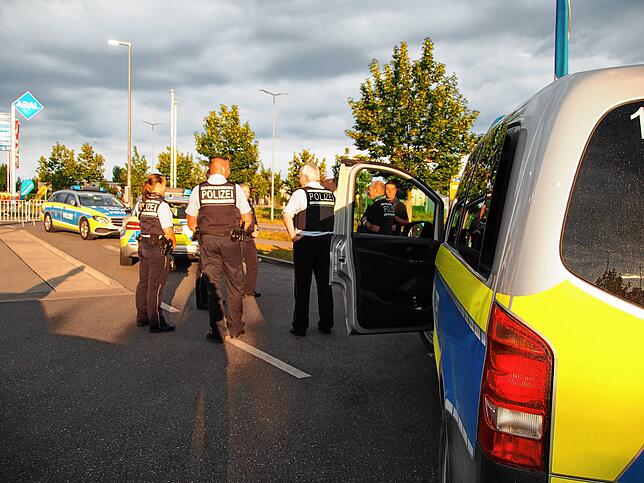 Einsatzkräfte der Singener Polizei besprechen die Lage auf dem Aral-Tankstellengelände.