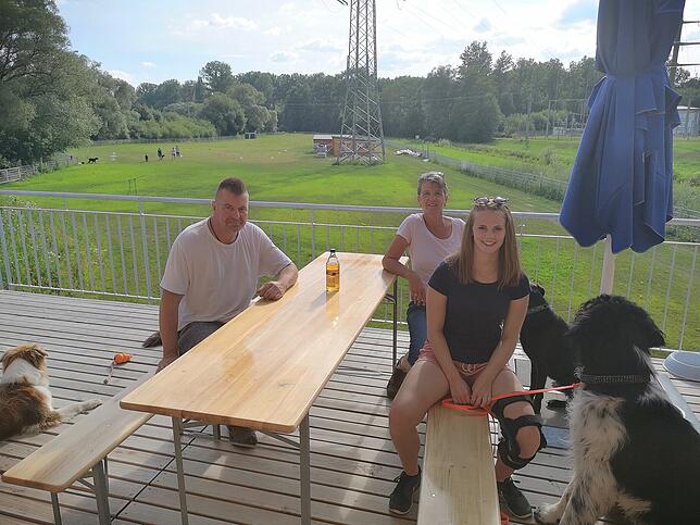 Blick von der Vereinsheim-Terrasse auf den Trainingsplatz. Fürs Foto haben sich umgedreht (von links): Roland Stickelmayer, Ines Wegen ...