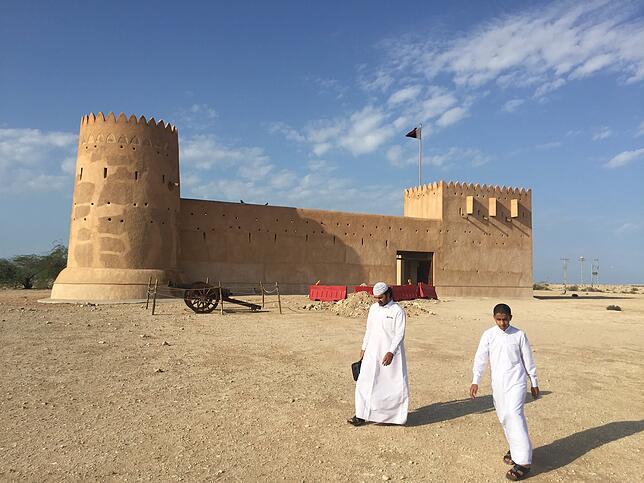 Zwei Männer vor dem Unesco-Weltkulturerbe Fort Al-Subara.