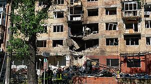 Feuerwehrleute arbeiten in einem zerstörten Wohnhaus nach einem russischen Drohnen- und Raketenangriff in Kiew.