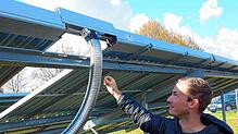 Projektleiter Sören Hilger zeigt an der Solarthermieanlage auf die Stelle, an der das von der Sonne erwärmte Wasser in das System ...