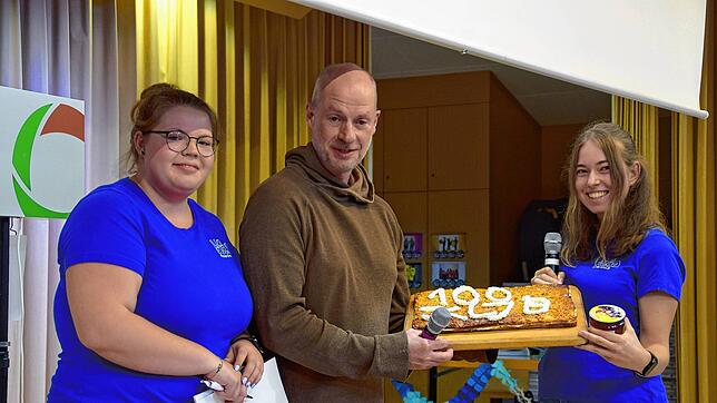 Ein besonderer Kuchen zum 100-jährigen: Miriam Kammerer (links) und Ines Albiez (rechts) freuen sich zusammen mit Pfarrer Bernhard ...