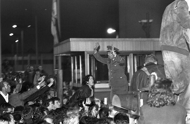 Wenige Stunden später: Ein DDR-Grenzsoldat versucht, den Ansturm der Bürger in geordnete Bahnen zu lenken.