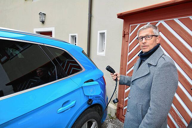 Bürgermeister Robert Scherer lädt an der Wallbox am städtischen Gebäude Zunftstube seinen Hybrid-Dienstwagen mit elektrischer Energie.