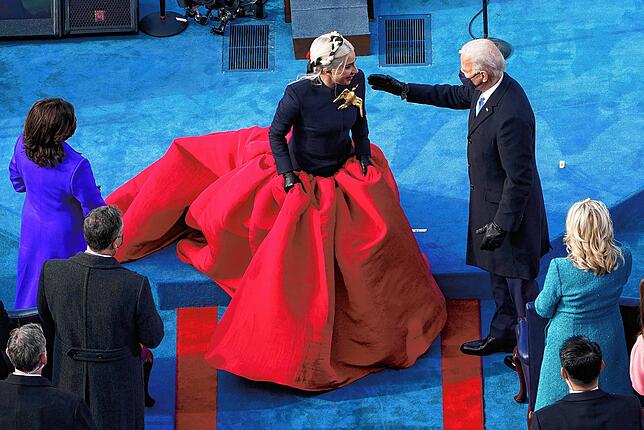 Biden begrüßt Lady Gaga in wallendem roten Rock. Ihr wurde Ehre zuteil, die Nationalhymne zu singen.