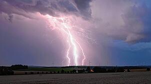 ARCHIV – Ein Blitz zuckt bei einem Sommergewitter am abendlichen Himmel über Bartholomä auf der Schwäbischen Alb.