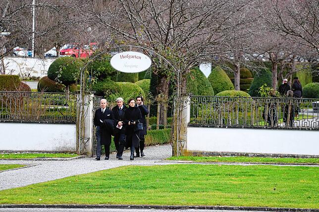 Trauergäste gehen über den Hofgarten in Richtung Münster.
