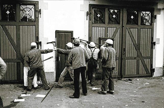 Die „Stadt“ holt sich ihren Besitz zurück: Mitarbeiter des Bauhofs brechen eine Türe des besetzten Feuerwehrhauses auf.