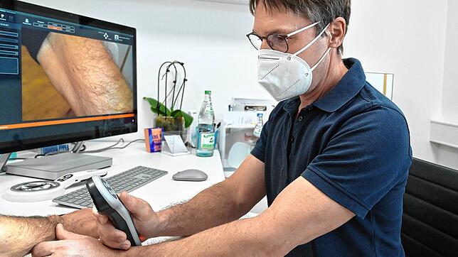 Der Radolfzeller Dermatologe Andras Rozsondai bei der Untersuchung eines Unterarmes auf Hautkrebs. Derartige Diagnosen häufen sich in ...
