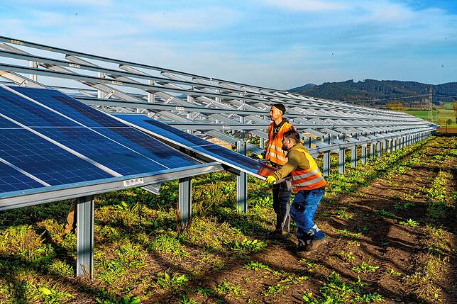 Nachdem die Träger für die Solarzellen montiert sind, müssen die Module darauf befestigt werden – und da gilt es kräftig anzupacken.