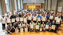 Aufstellen zum Gruppenbild, in den Hänen die Auszeichnungen: Der Aluminiumbetrieb Constellium ehrt seine Mitarbeitenden der Standorte ...