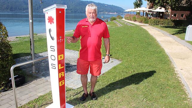 Karl-Heinz Rimmele, Vorsitzender der DLRG-Ortsgruppe Sipplingen, zeigt auf die Notrufsäule, die am Naturstrand in Sipplingen steht.