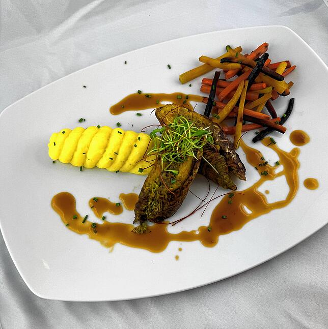 Veganes Hauptgericht: Crépinette vom Wirsing mit einer Pilzfüllung, Sherry-Jus, Sellerie-Merrettichpüree und glacierten Retrokarotten.