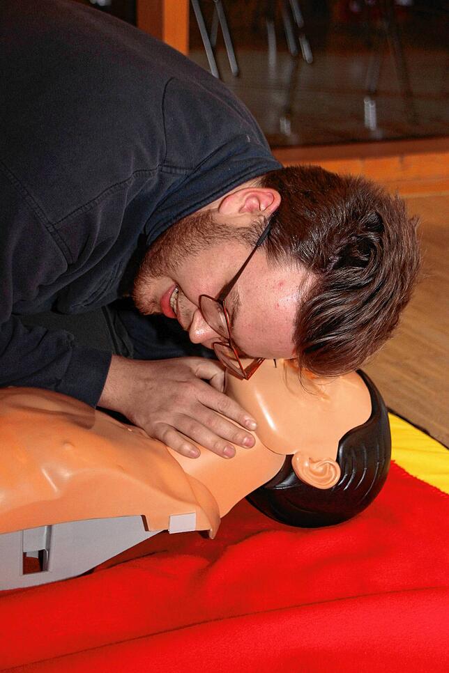 Mit dem Ohr an Mund und Nase kontrolliert Jonas Engel, ob die Person noch atmet.
