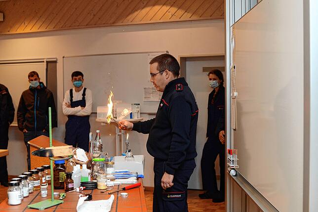 Ausbilder Tobias Schulz demonstriert, wie schnell Holz, hier in Form von luftiger Holzwolle, in Flammen aufgehen kann.