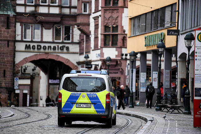 Vergewaltigung in Freiburg Ein Polizeifahrzeug fährt in der Fußgängerzone vor dem Martinstor. Nach der mutmaßlichen Vergewaltigung einer 18-Jährigen durch mehrere ...
