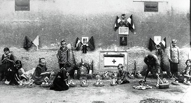 Erschreckende Idylle: Diese Fotografie zeigt Kinder, die 1915, im zweiten Jahr des ersten Weltkriegs, auf dem Münsterplatz ihren Alltag ...