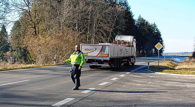 Polizeihauptkommissar Manfred Abbieri winkt die Fahrzeuge in die Kontrollstelle ein.