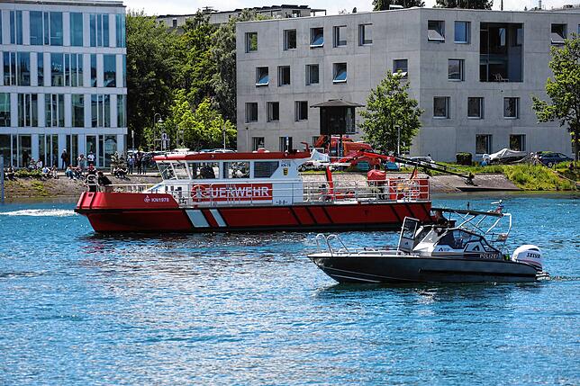 Boote der Polizei und Feuerwehr sowie die DLRG sind an der Suche auf dem Seerhein beteiligt. Über dem Wasser kreist ein ...