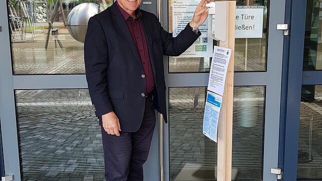 Manfred Weber, Bürgermeister der Gemeinde Küssaberg, vor dem Rathaus im Gemeindezentrum in Rheinheim mit dem Ständer, an dem ...